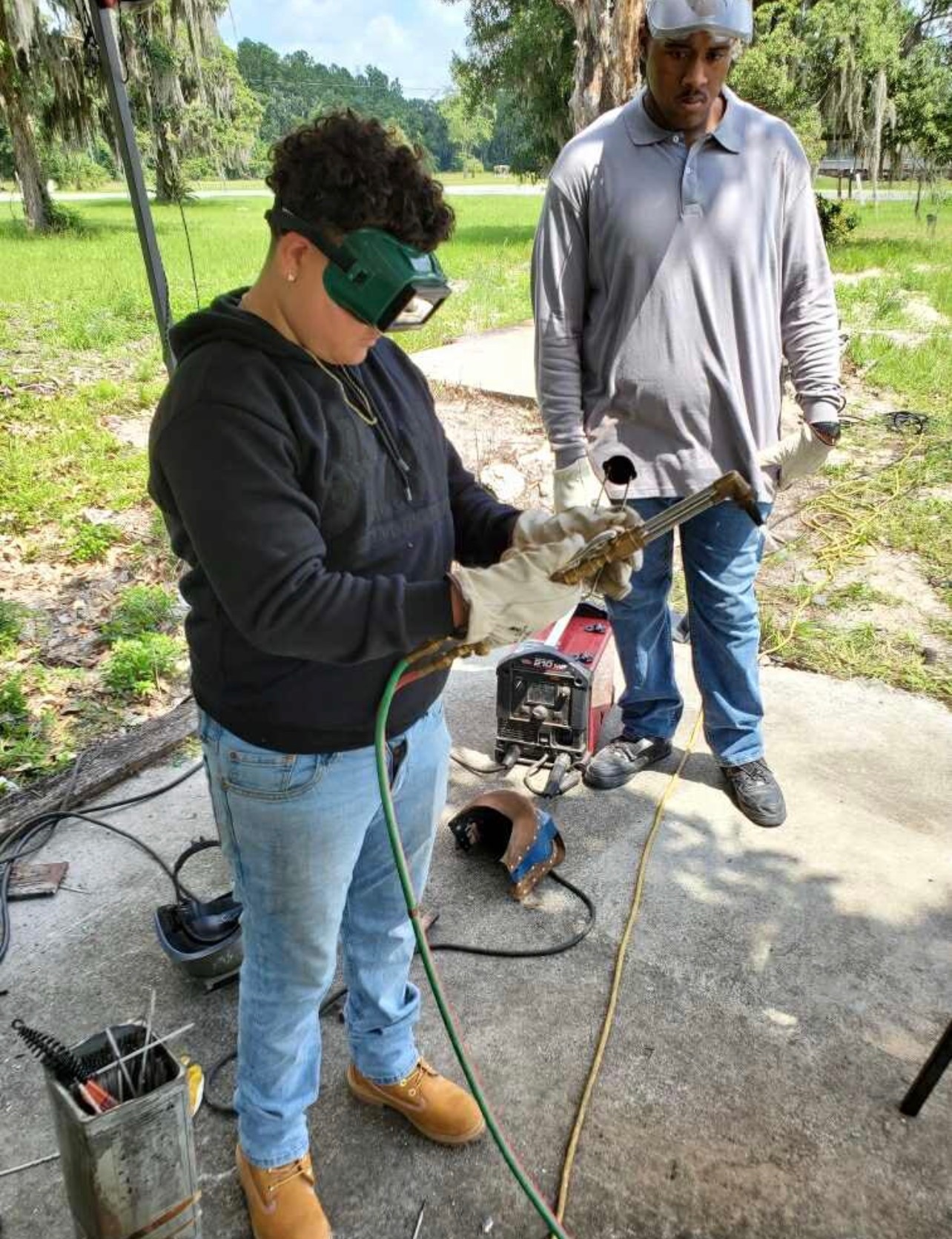 Welding helmet and torch in use during training
